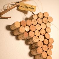 Wanddekoration in Traubenform aus Weinkorken mit einem Schild mit der Aufschrift „Merlot“.